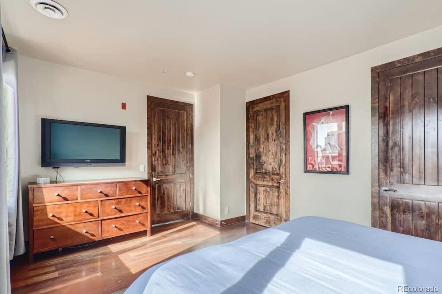 2101 Larimer Street, Unit 303 Denver, CO 80205 - Photo 12 of 21 a bedroom with furniture and flat screen tv