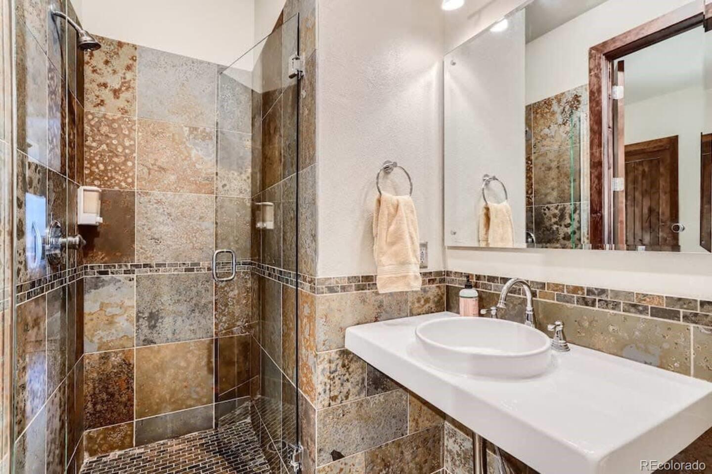 2101 Larimer Street, Unit 303 Denver, CO 80205 - Photo 18 of 21 a bathroom with a granite countertop shower a sink and a mirror