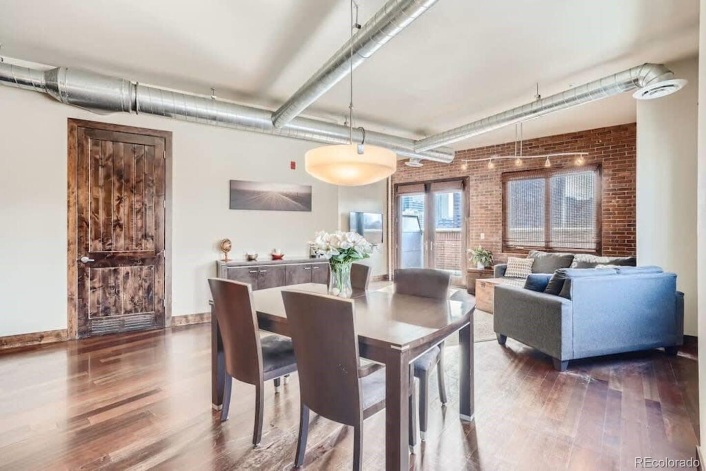 2101 Larimer Street, Unit 303 Denver, CO 80205 - Photo 7 of 21 a view of a dining room with furniture and wooden floor