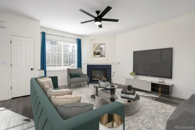 a living room with furniture a flat screen tv and a fireplace