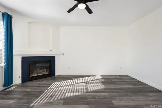 a view of a livingroom with wooden floor and a fireplace