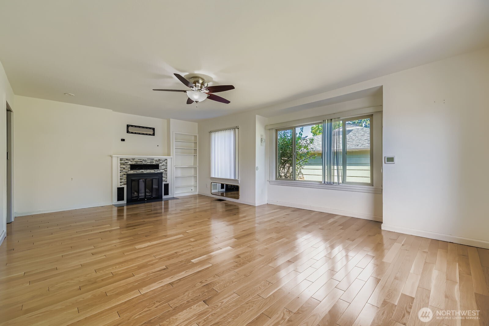 7806 Beverly Boulevard Everett, WA 98203 - Photo 5 of 22 an empty room with wooden floor and chandelier fan