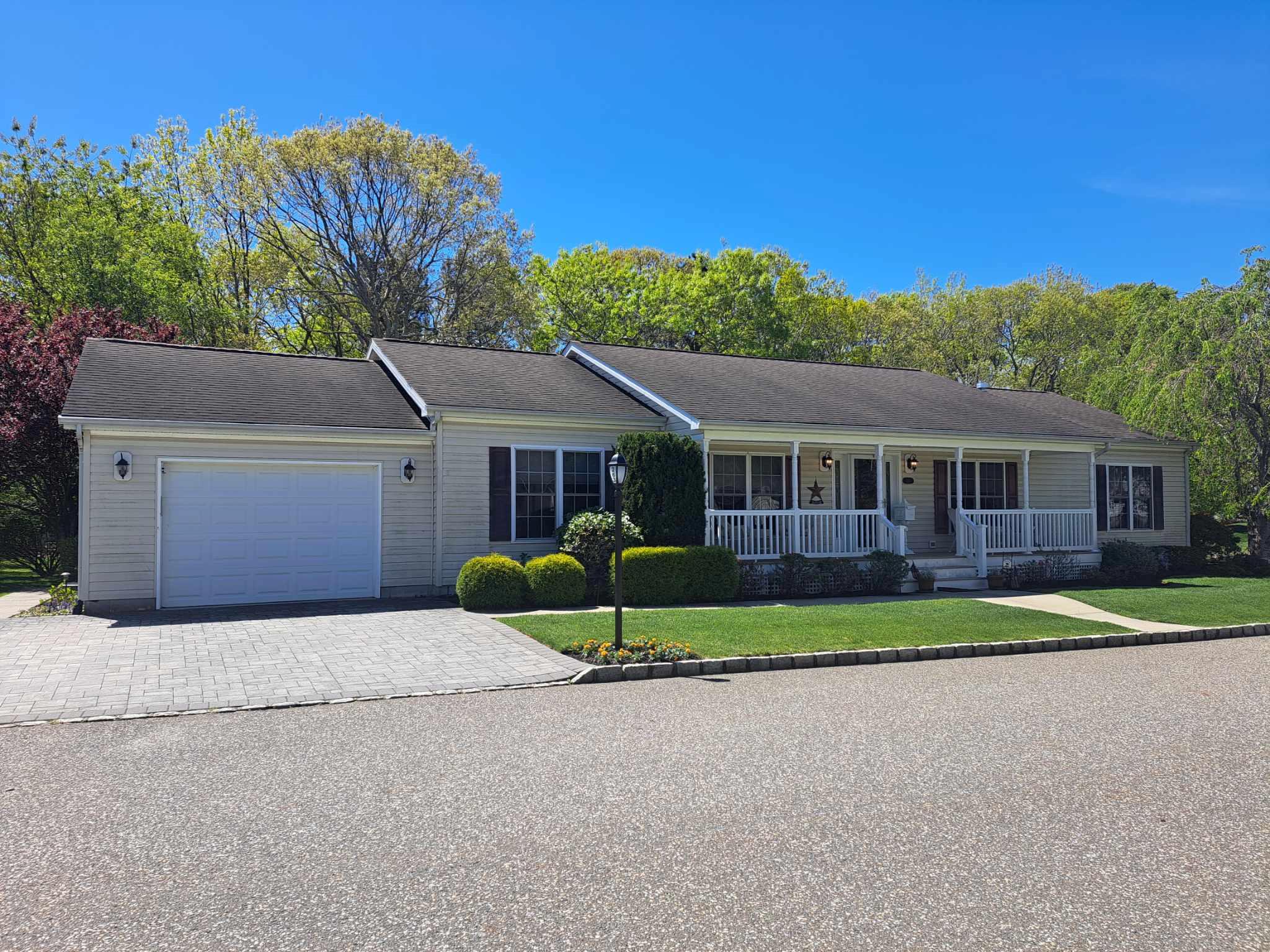 1407-263 Middle Road, Unit 263 Calverton, NY 11933 - Photo 1 of 1 Ranch-style home featuring a porch, a garage, and a front lawn