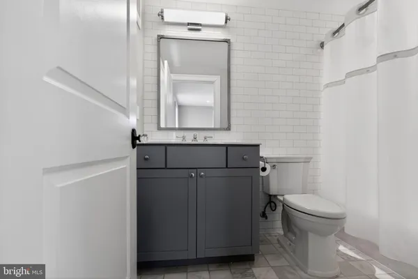 a bathroom with a toilet a sink and mirror