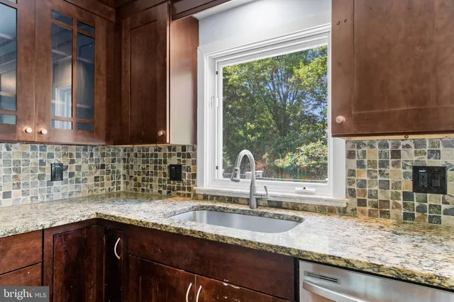 a kitchen with granite countertop a sink and a window