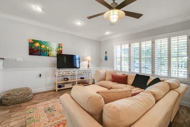 a living room with furniture flat screen tv and a large window