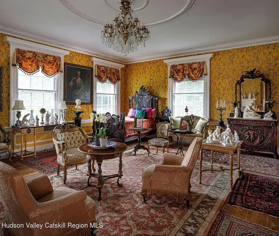 a living room with furniture a large window and a chandelier