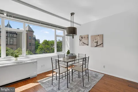 a dining room with furniture a chandelier and wooden floor
