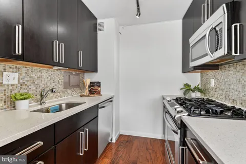 a kitchen with stainless steel appliances a sink stove and cabinets