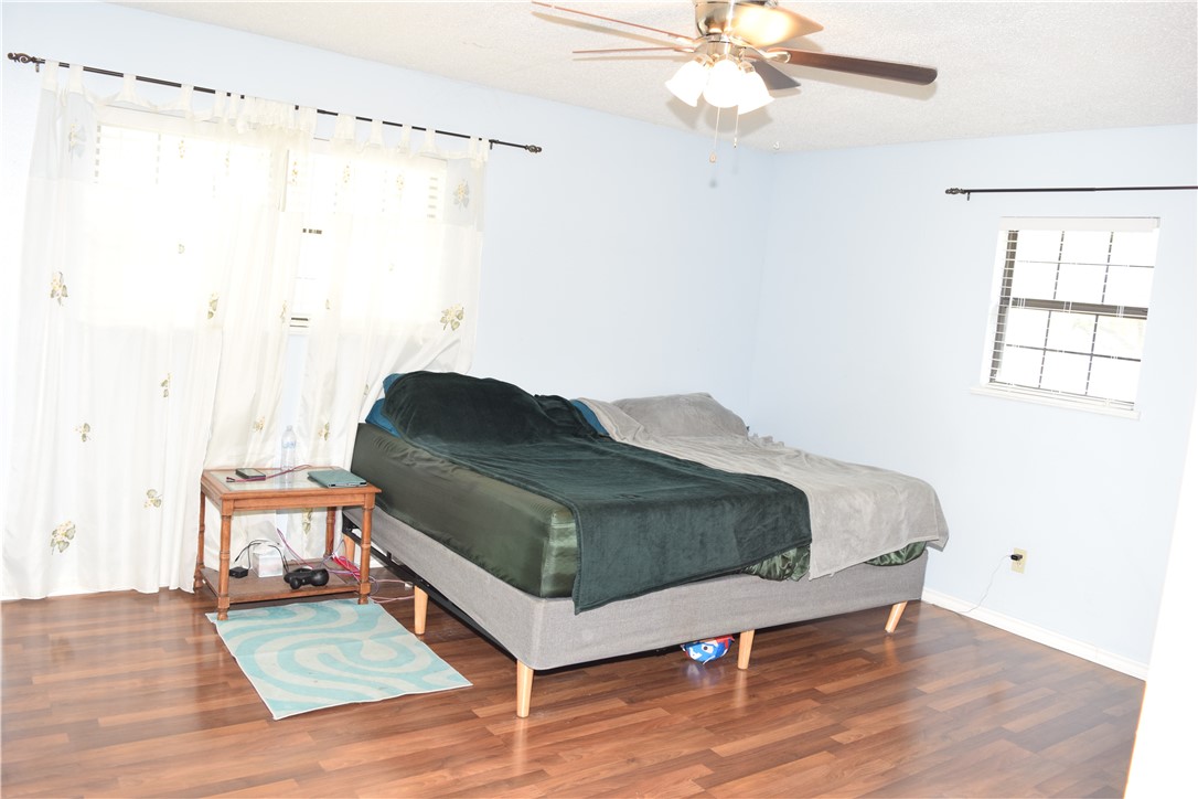 24772 County Road 360 Mathis, TX 78368 - Photo 8 of 30 a bedroom with a bed and a chandelier