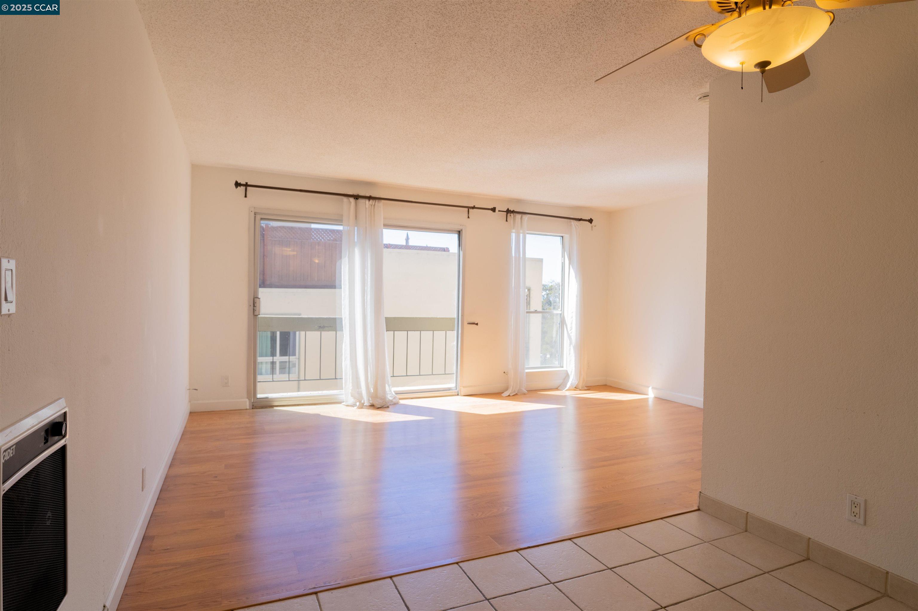 466 Crescent Street, Unit 306 Oakland, CA 94610 - Photo 13 of 26 an empty room with wooden floor and windows