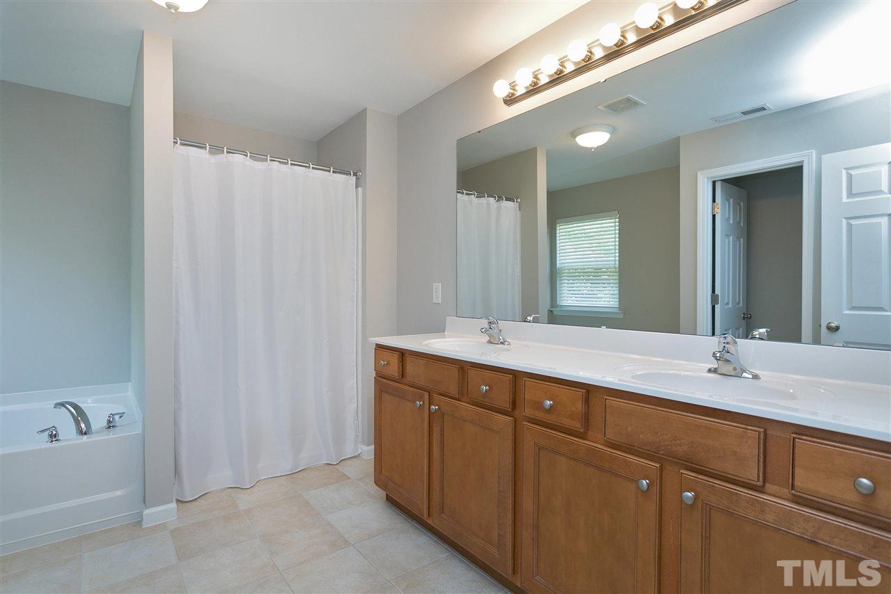 118 Key Biscayne Court Raleigh, NC 27603 - Photo 21 of 30 a spacious bathroom with a double vanity sink a mirror and a bathtub