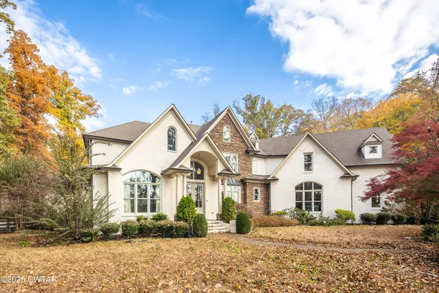 a view of a white house with a yard