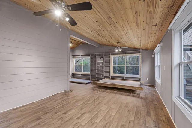 a view of front door with wooden floor and a ceiling fan