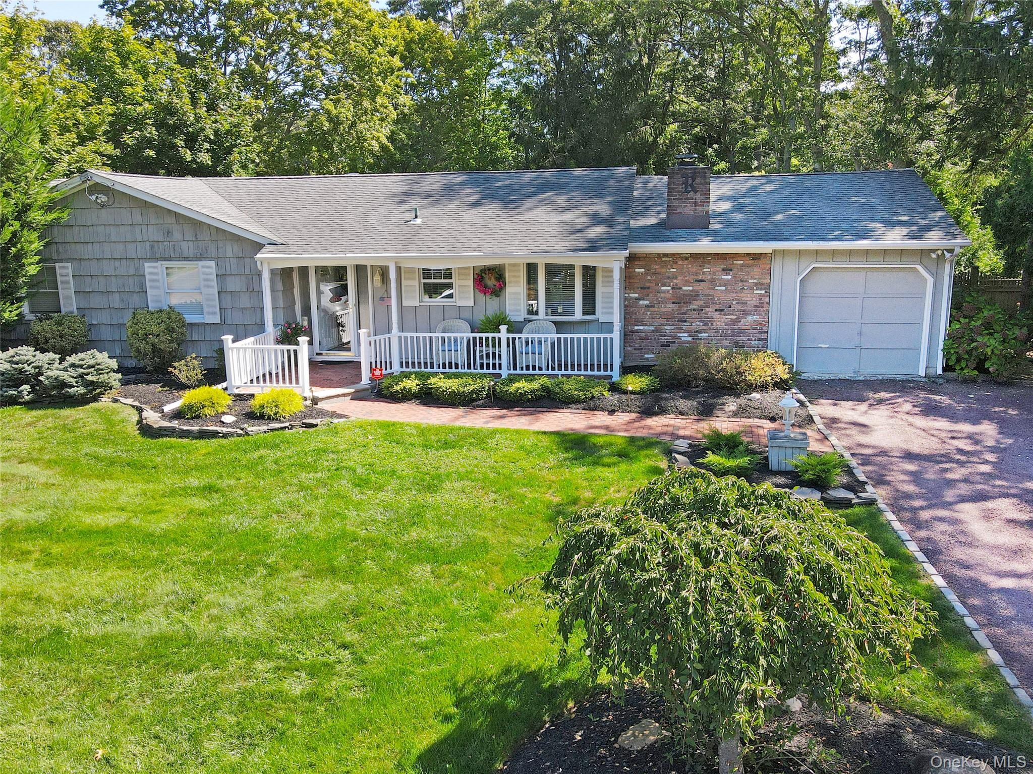72 Mahogany Road Rocky Point, NY 11778 - Photo 1 of 1 a patio with table and chairs and potted plants
