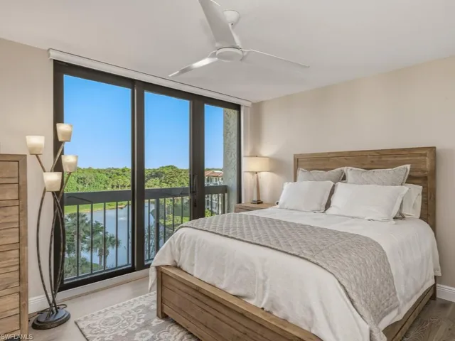 a large bed sitting in a bedroom next to a window