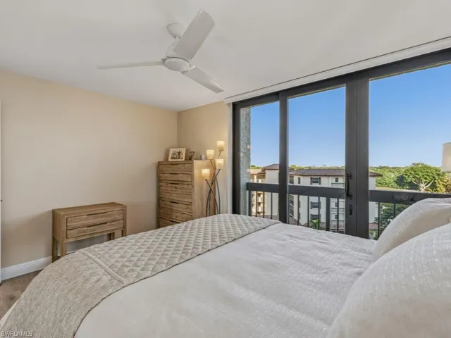 a bedroom with a large bed and a balcony view