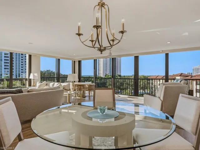 a dining room with furniture a chandelier and wooden floor