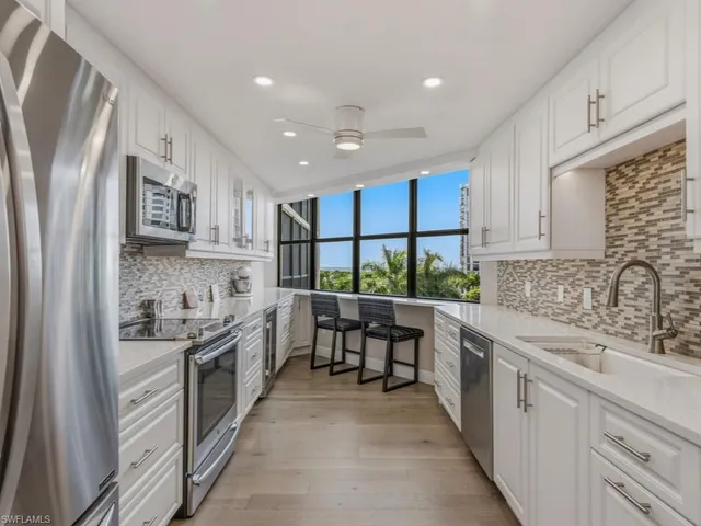 a kitchen with stainless steel appliances granite countertop lots of counter top space and wooden floor