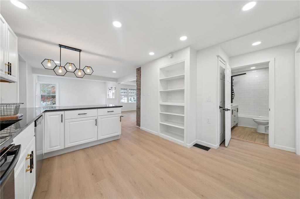 624 6th Street Mather, PA 15346 - Photo 11 of 26 a kitchen with white cabinets and wooden floor