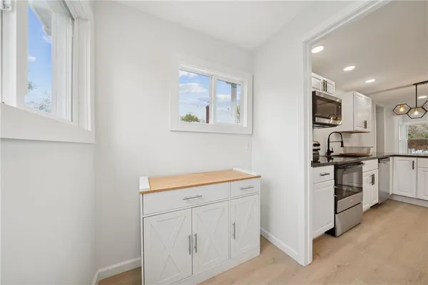 a kitchen with white cabinets and stainless steel appliances