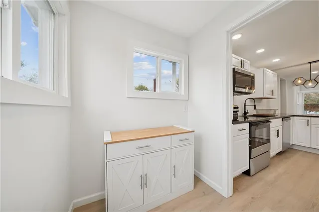 a kitchen with white cabinets and stainless steel appliances