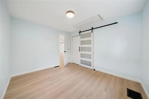 a view of empty room with wooden floor