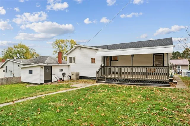 a view of a house with a big yard and large tree