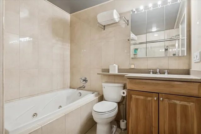 a bathroom with a granite countertop sink a toilet and bathtub