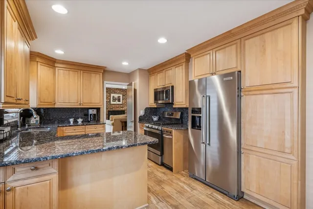 a kitchen with stainless steel appliances granite countertop a refrigerator and a sink