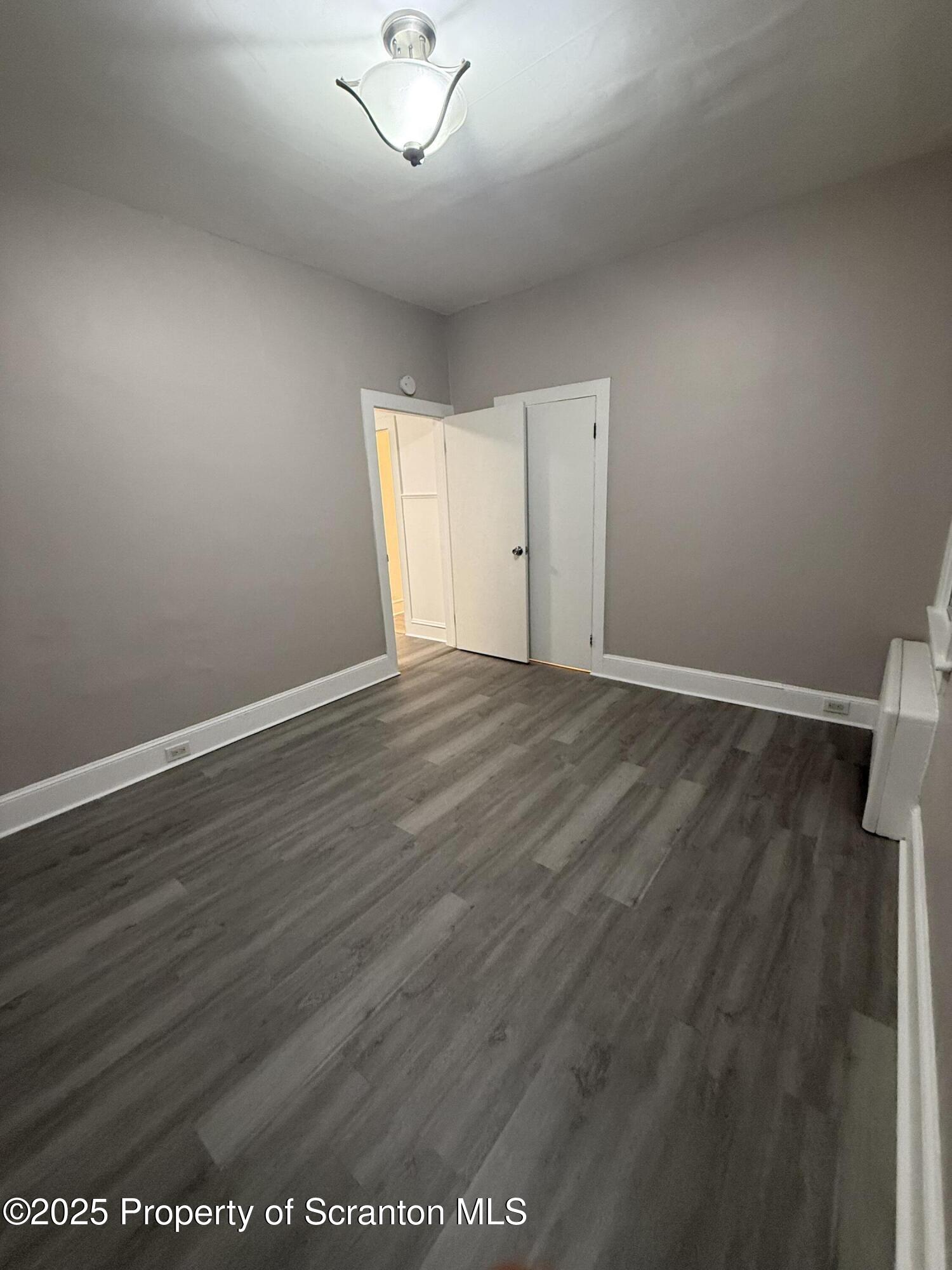 929 Stafford Avenue, Unit 2 Scranton, PA 18505 - Photo 4 of 8 an empty room with wooden floor and windows