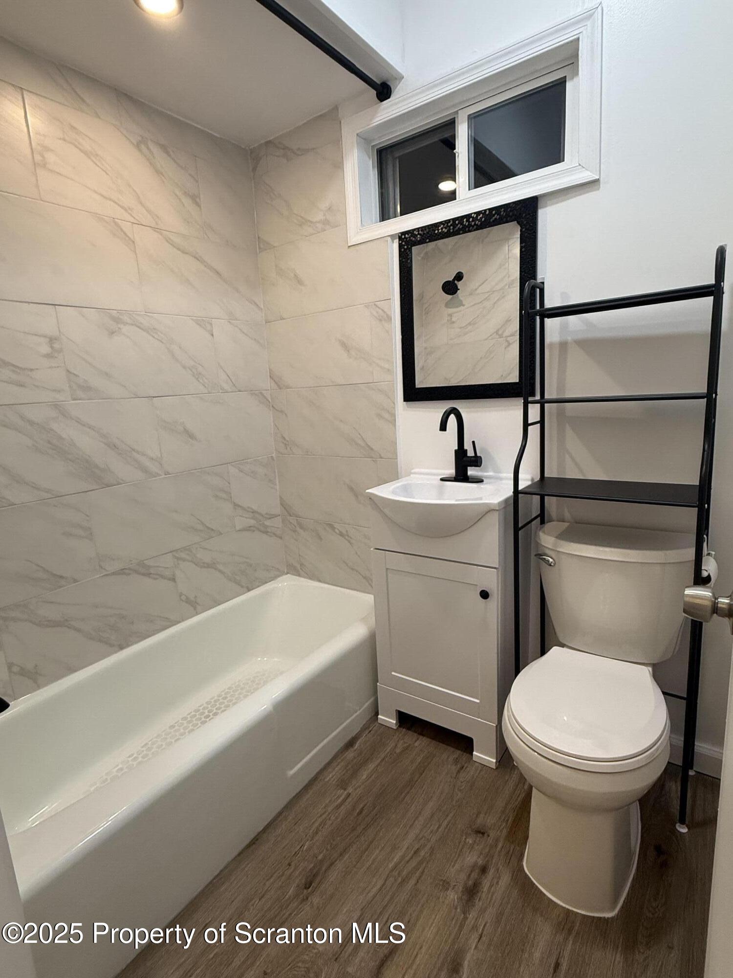 929 Stafford Avenue, Unit 2 Scranton, PA 18505 - Photo 5 of 8 a bathroom with a toilet sink and mirror