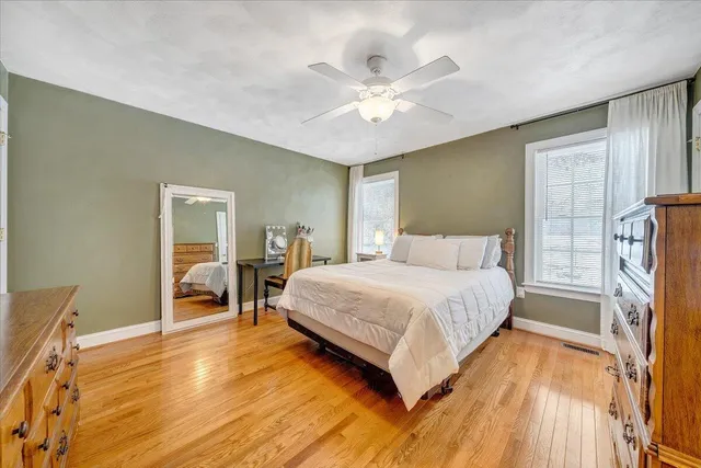 a bedroom with a bed and wooden floor