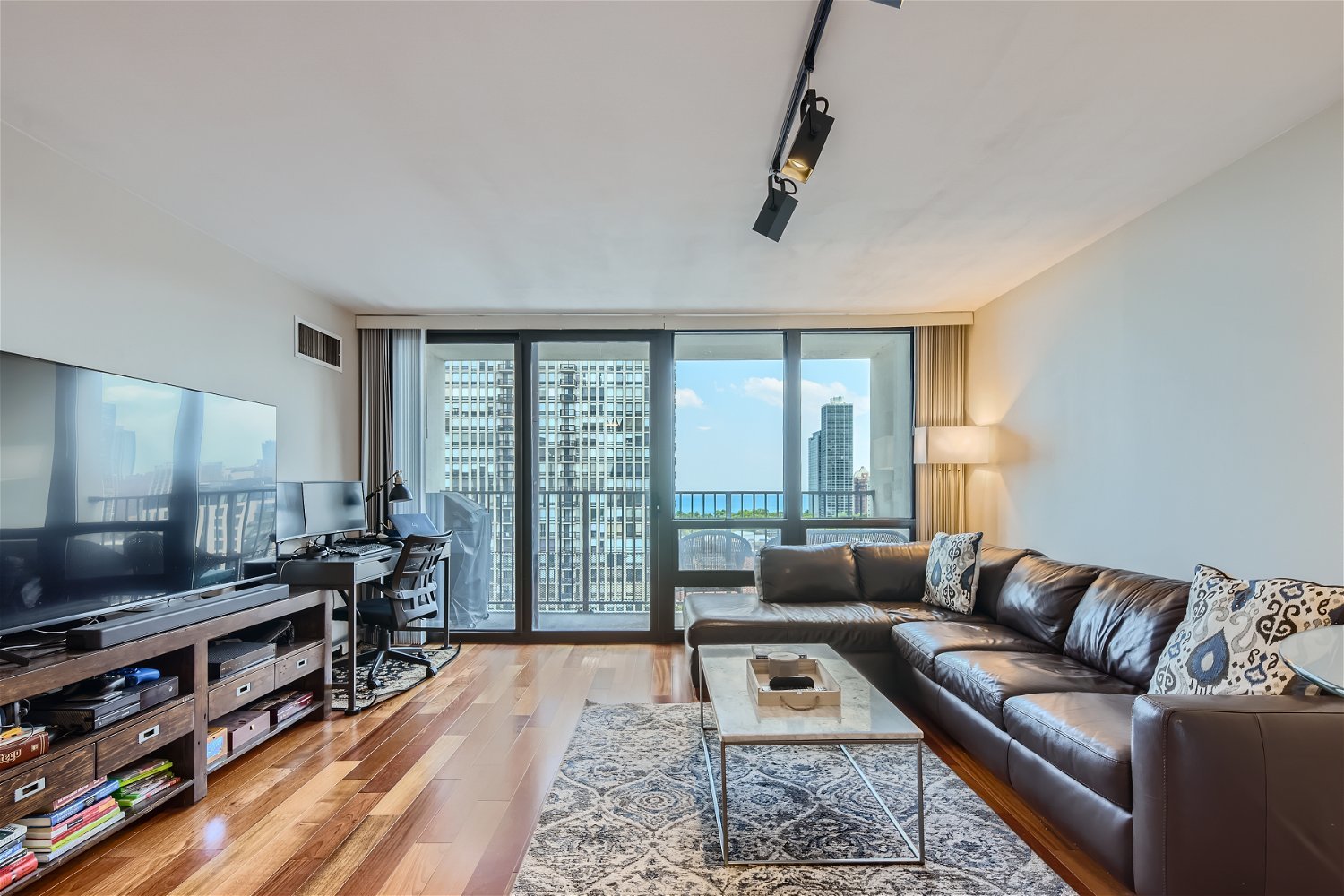 1636 North Wells Street, Unit 1505 Chicago, IL 60614 - Photo 4 of 21 a living room with furniture a flat screen tv and a floor to ceiling window