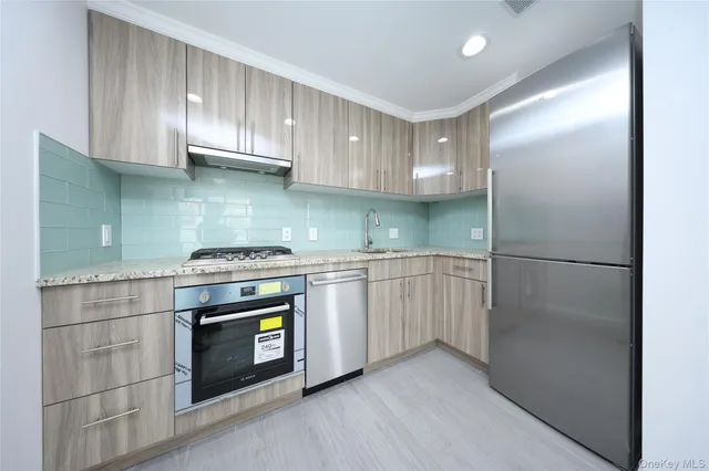 a kitchen with stainless steel appliances granite countertop a stove a refrigerator and a cabinets