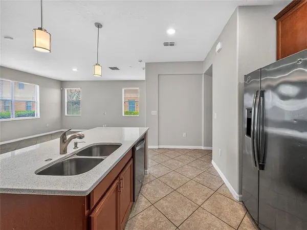 a kitchen that has a sink a refrigerator and cabinets