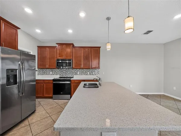 a kitchen with stainless steel appliances granite countertop a sink a stove and a refrigerator