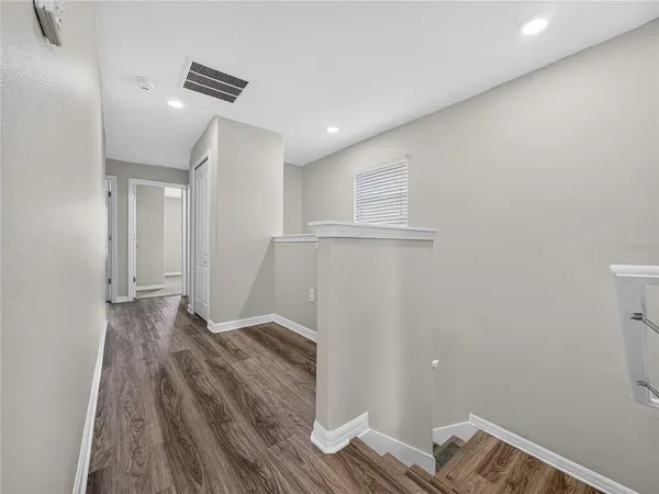 a view of empty room with wooden floor