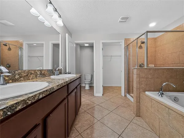 a bathroom with a granite countertop sink a mirror and a bathtub