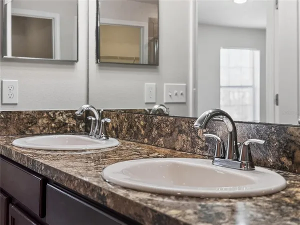 a bathroom with a granite countertop sink and a mirror