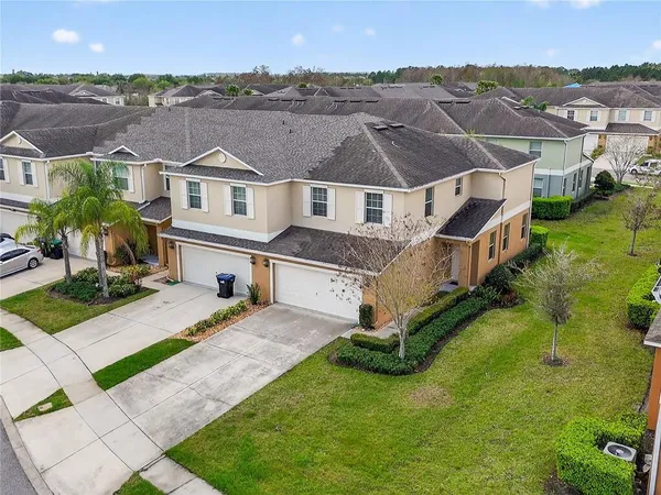a front view of a house with a yard and trees