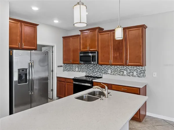a kitchen with stainless steel appliances granite countertop a refrigerator a sink and a stove