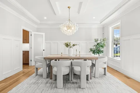 a dining room with furniture a chandelier and wooden floor