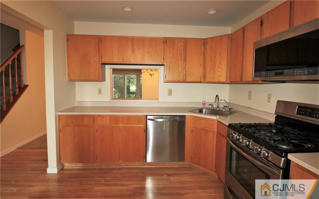 64 Goodwin Drive North Brunswick, NJ 08902 - Photo 5 of 25 a kitchen with stainless steel appliances granite countertop a stove a sink and a microwave