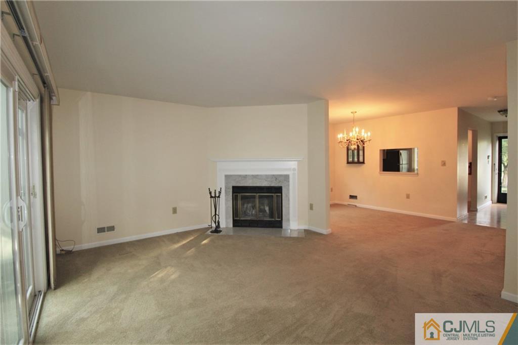 64 Goodwin Drive North Brunswick, NJ 08902 - Photo 9 of 25 a view of an empty room with a fireplace and a window