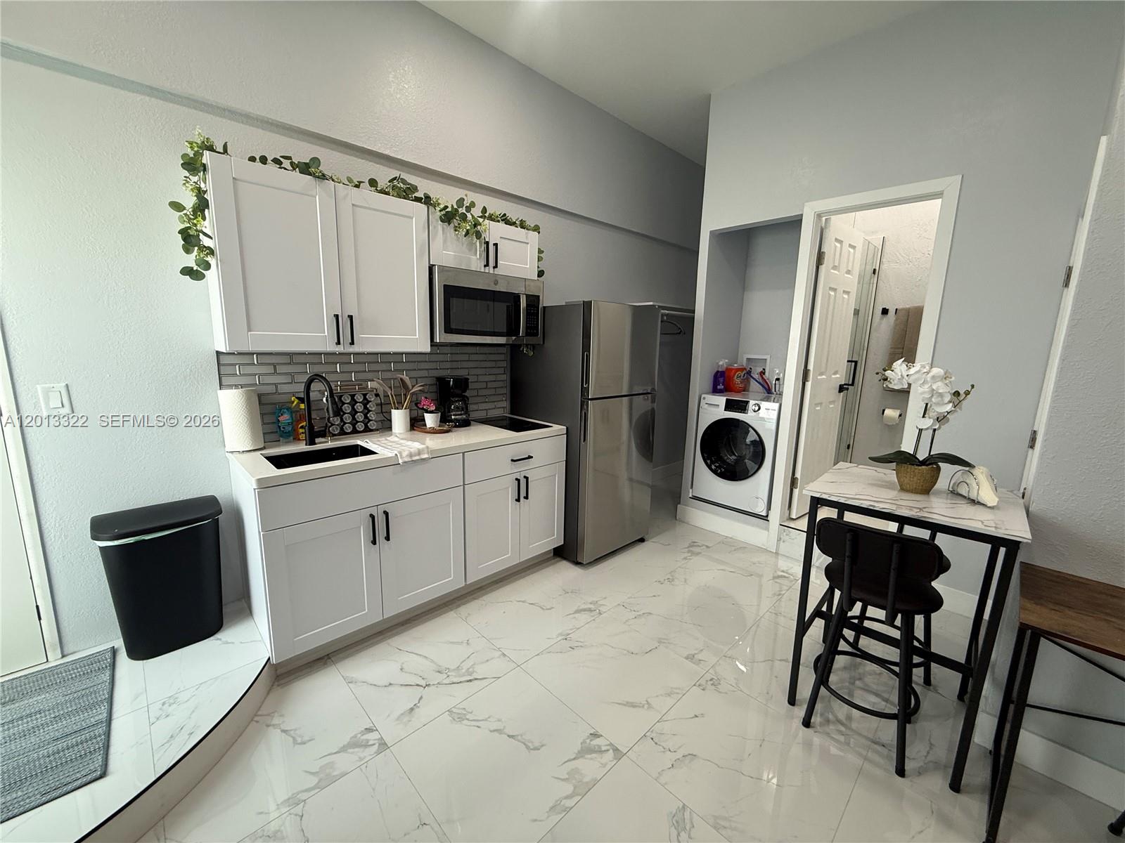 13204 Southwest 228th Street, Unit A Miami, FL 33170 - Photo 2 of 8 a kitchen with stainless steel appliances a stove a sink a microwave a refrigerator and cabinets