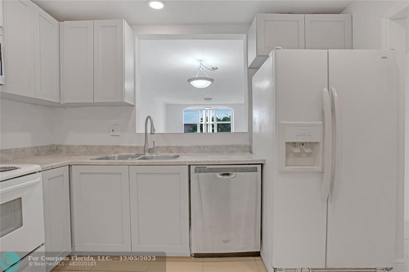 a kitchen with cabinets and white stainless steel appliances