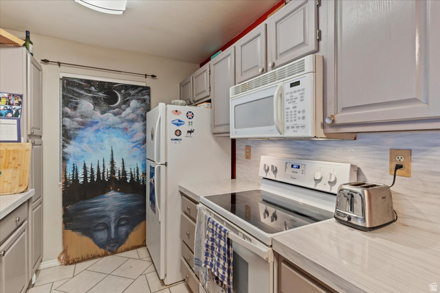 650 South Main Street, Unit 4104 Bountiful, UT 84010 - Photo 11 of 22 Kitchen with white appliances, light countertops, light tile patterned flooring, and gray cabinetry