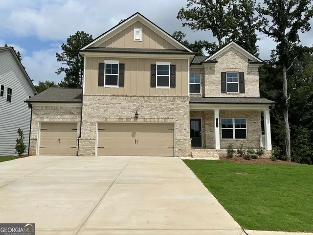 a front view of a house with a yard and trees
