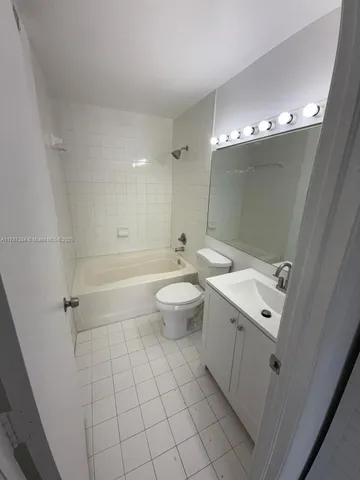 a bathroom with a double vanity sink mirror and toilet